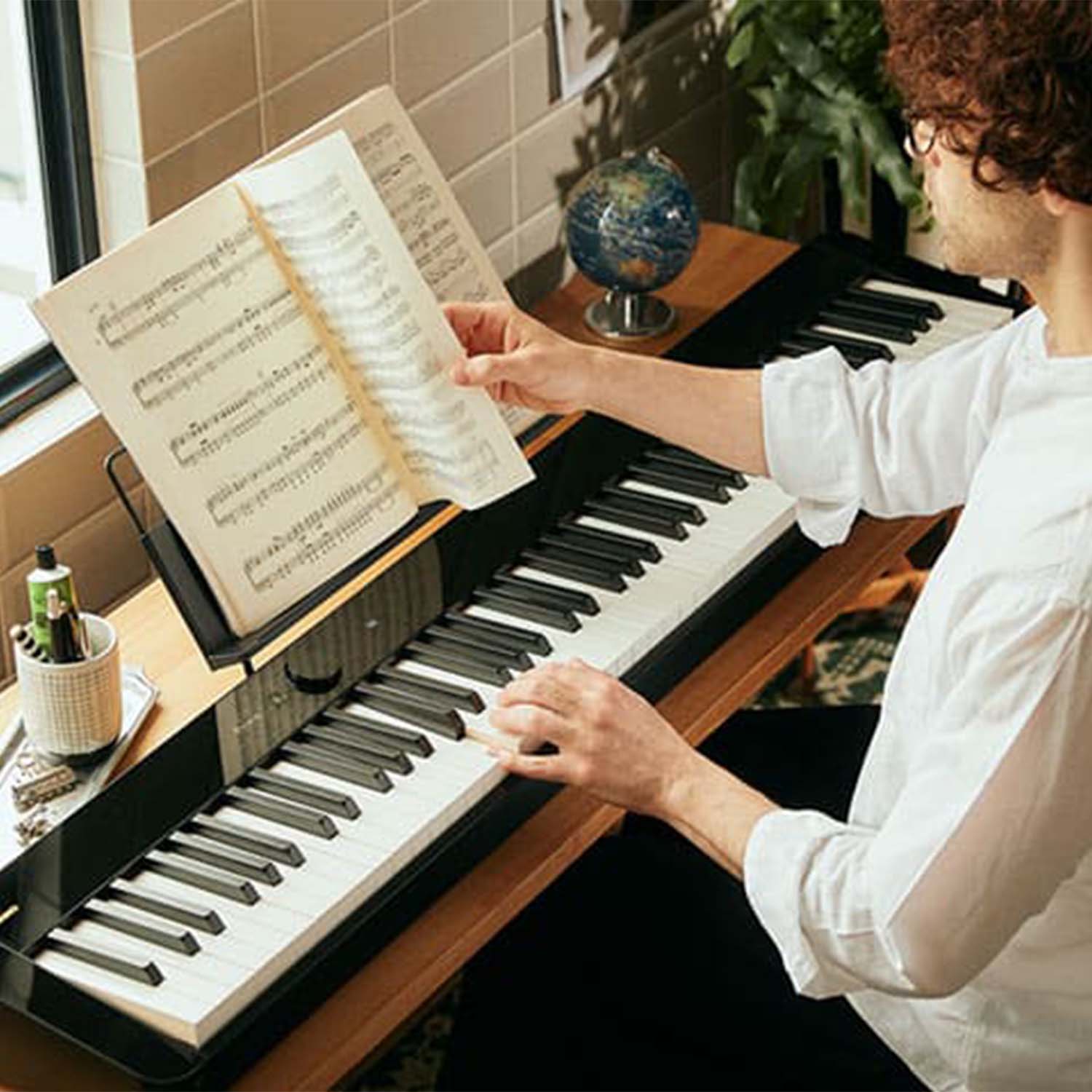 Young Man reading music while playing Casio PXS5000