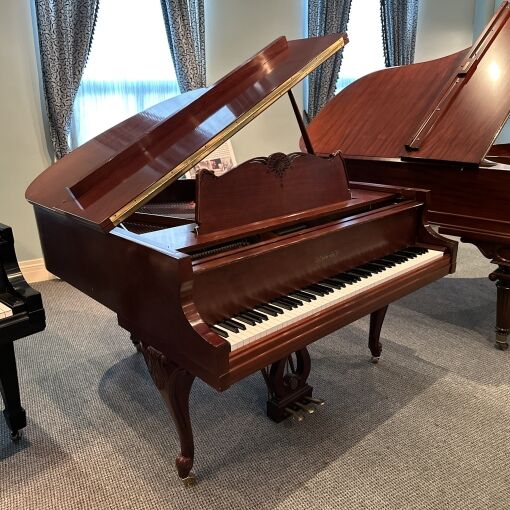 Wide picture of a Chickering and Sons Louis XV style Baby grand piano in satin mahogany