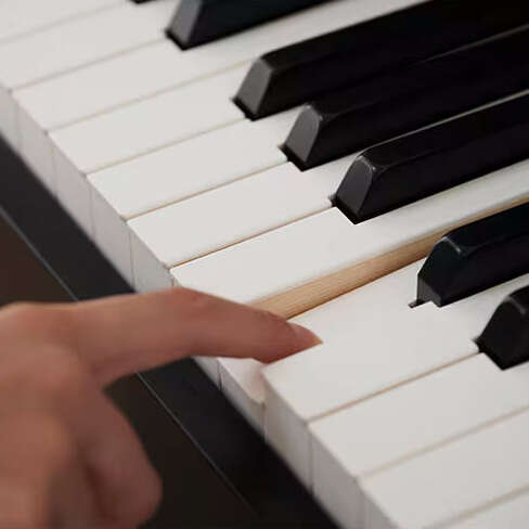 Finger pressing a key down on a Casio AP-550