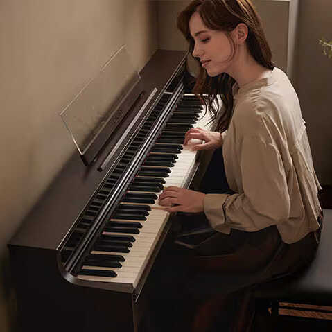 A woman playing a Casio AP-S450 in a living room